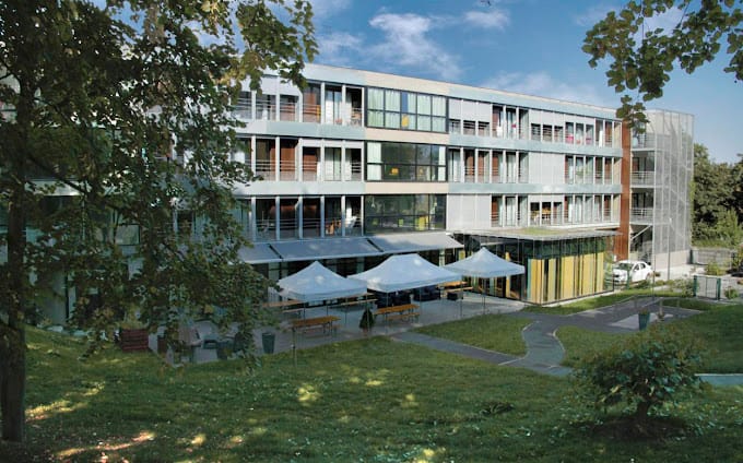 Photo de la façade arrière de la Résidence-Ehpad Le Clos Saint Martin (35) dans son écrin de verdure, insistant sur le confort et l'accueil des résidents - comme dans le projet accompagné par Hoppen